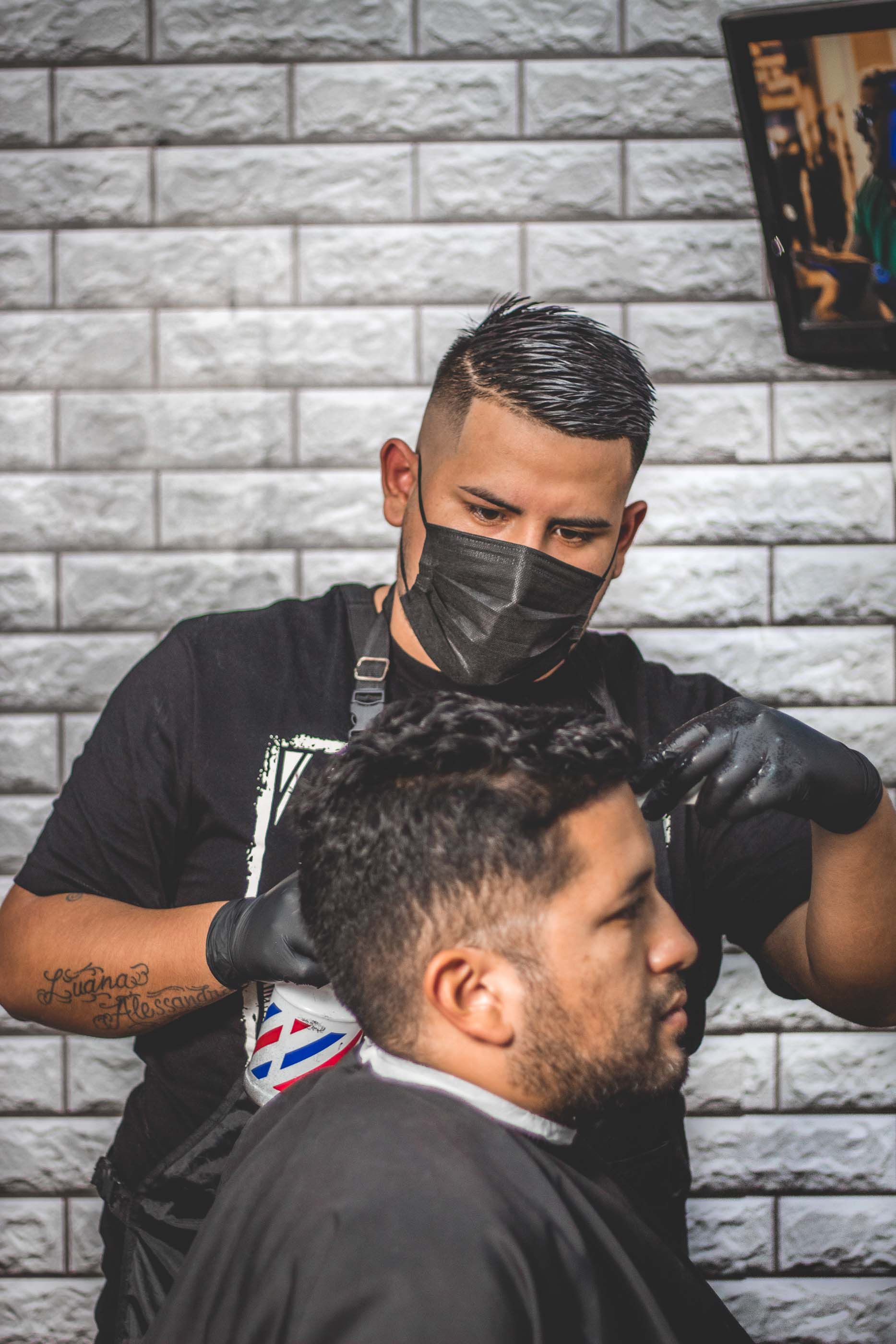 A barber finishing a cut in their shop