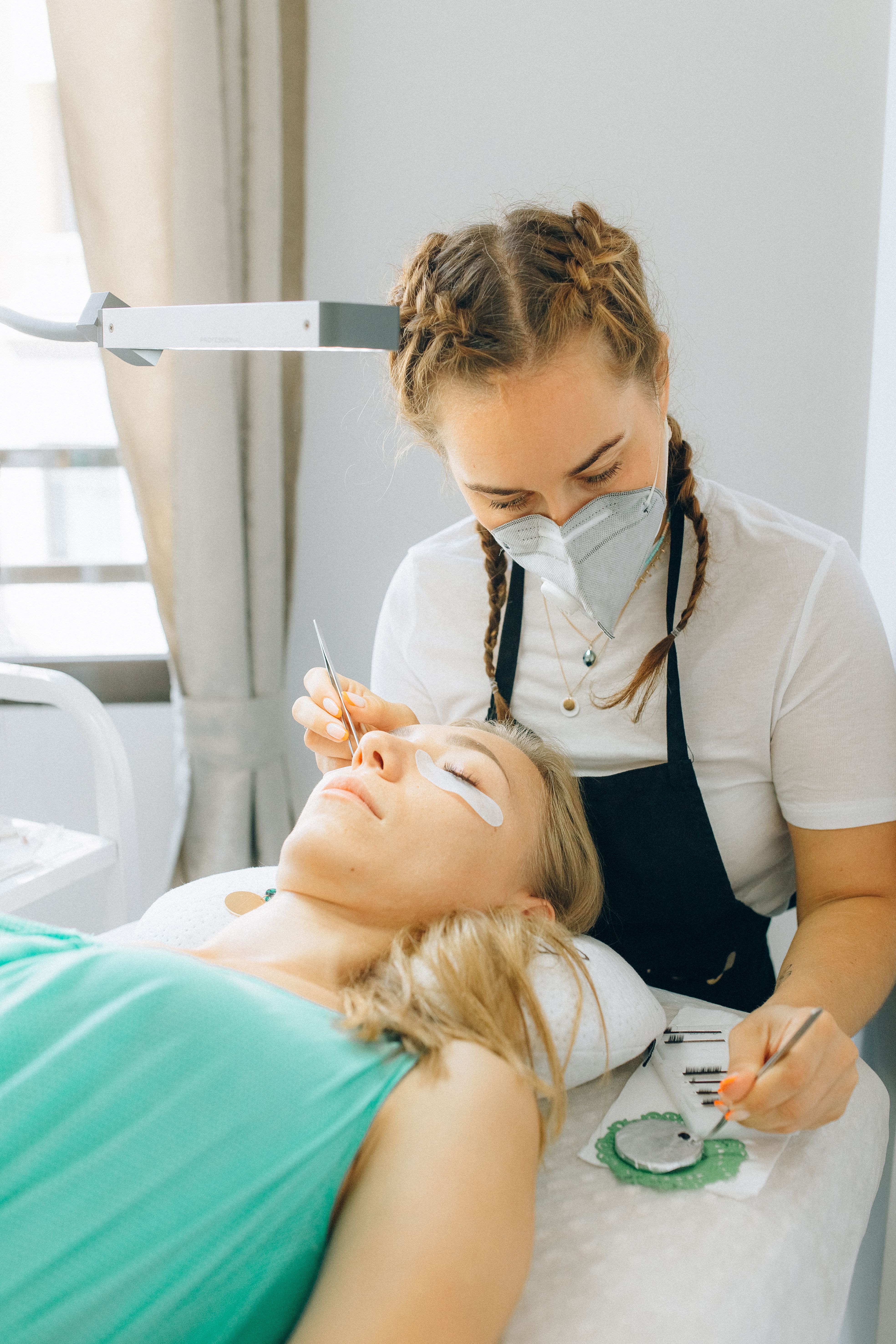 A lash technician applying extensions in a studio
